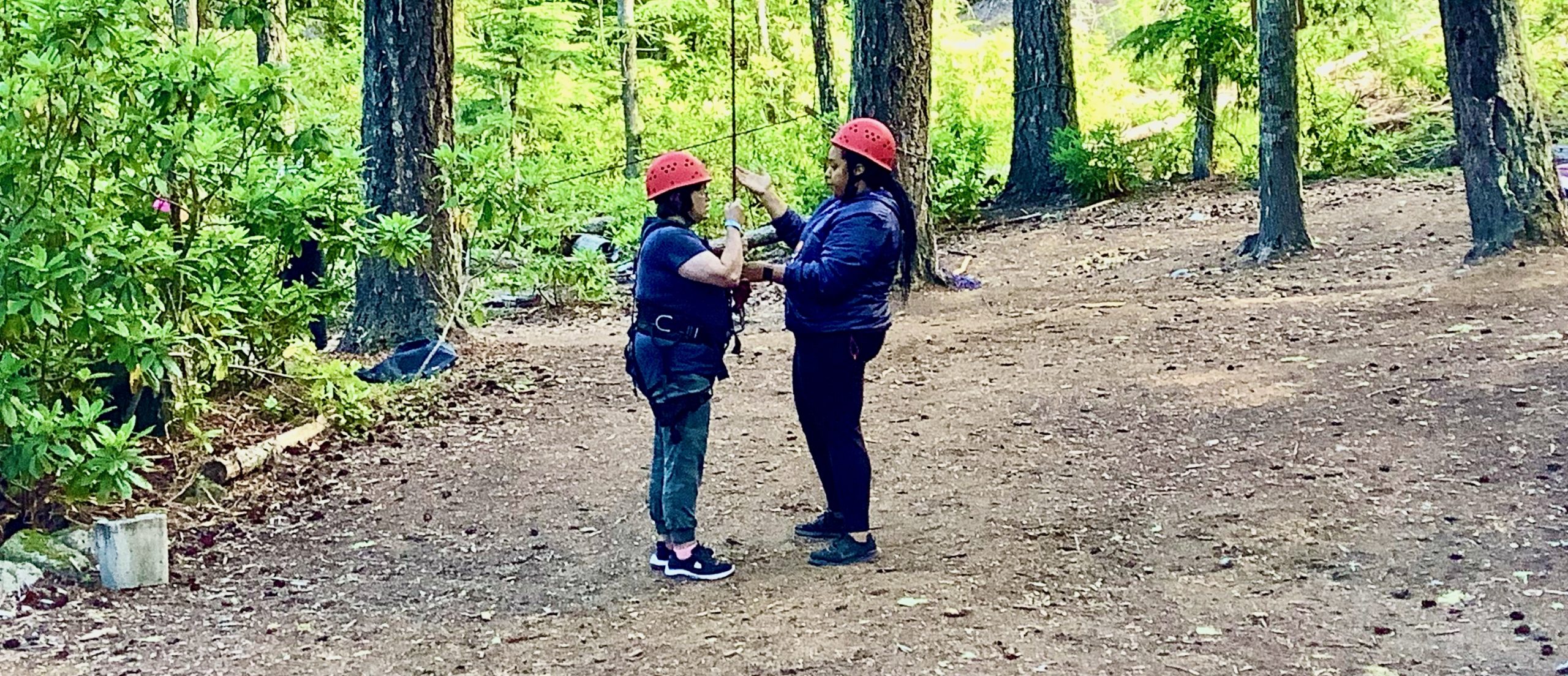 Photo: Ropes course staff explaining the flying squirrel to a camper.