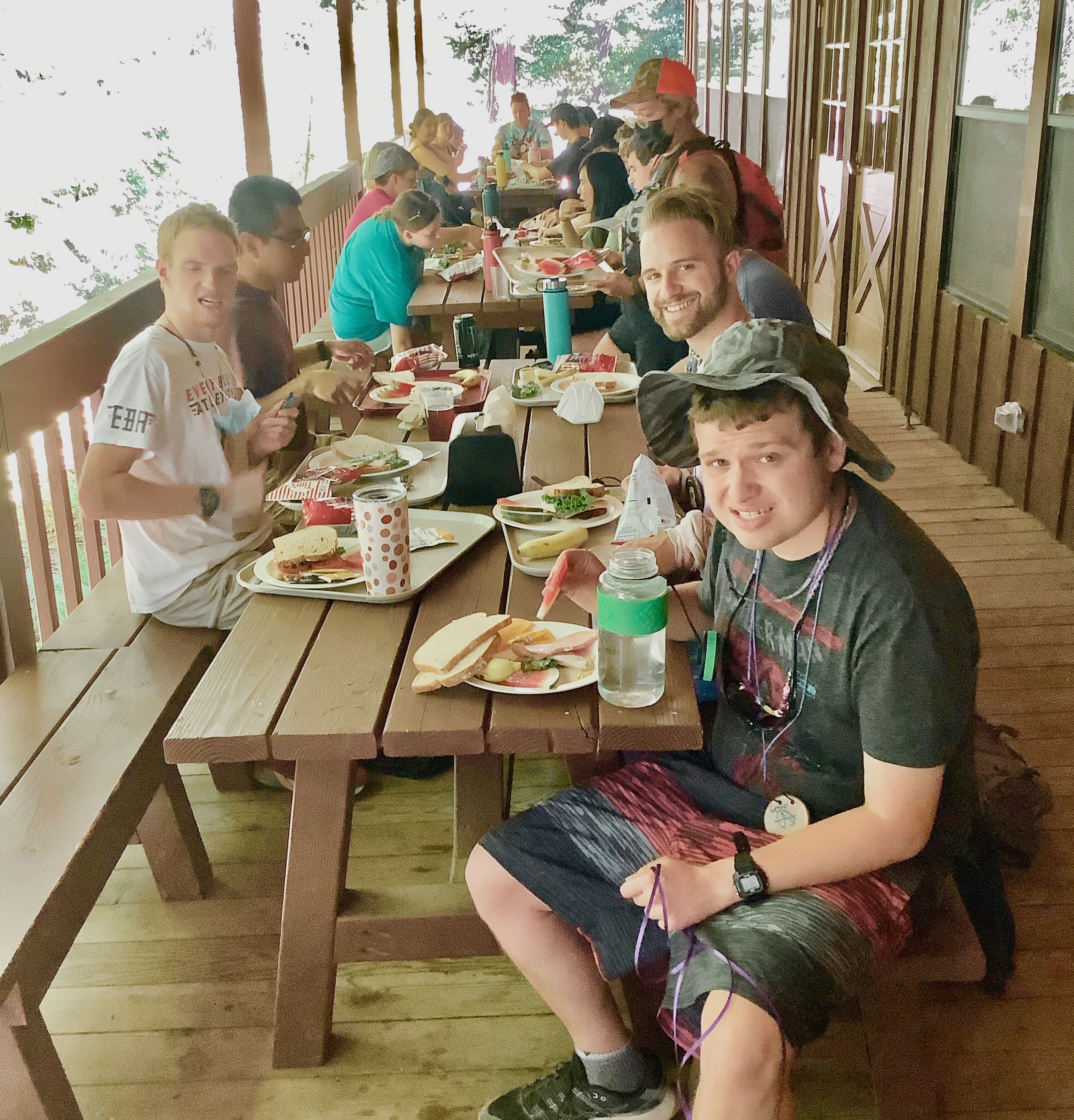 Photo: Camper group eating lunch at the picnic tables on the deck behind Fanning Hall.