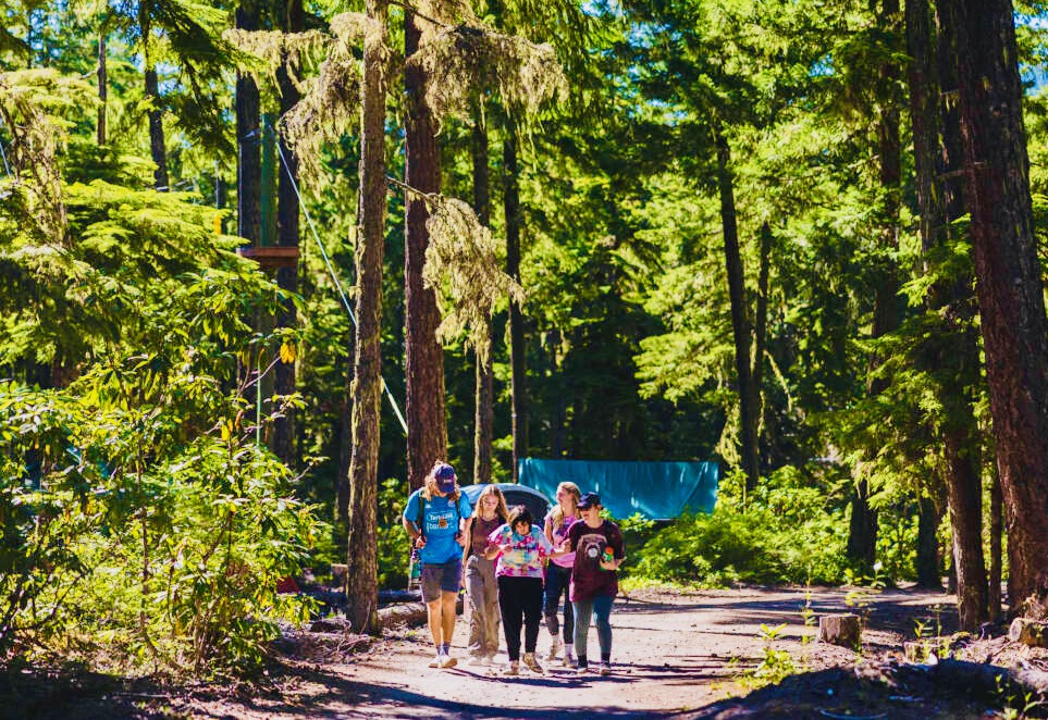 Group of campers and counselors walking in the woods.