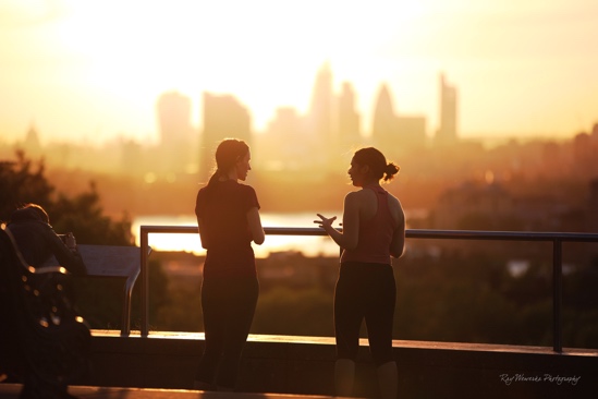 Photograph: Two people talking in front of a sunset