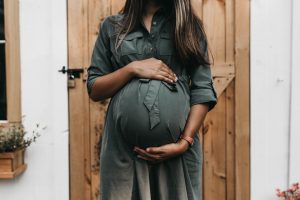 A pregnant person holds their belly