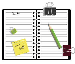 A notebook, pencil, binder clips, and sticky note