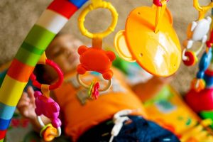 baby playing with a mobile while laying on the floor